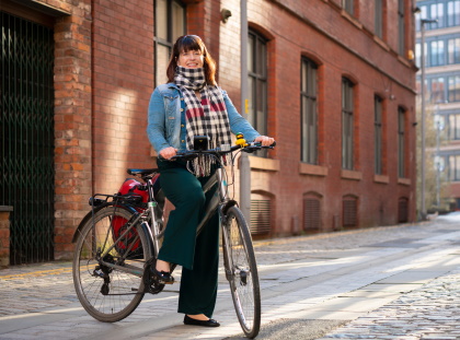 Lady with a tartan scarf riding a bike