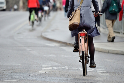 Woman on a bike wearing a rain jacket.